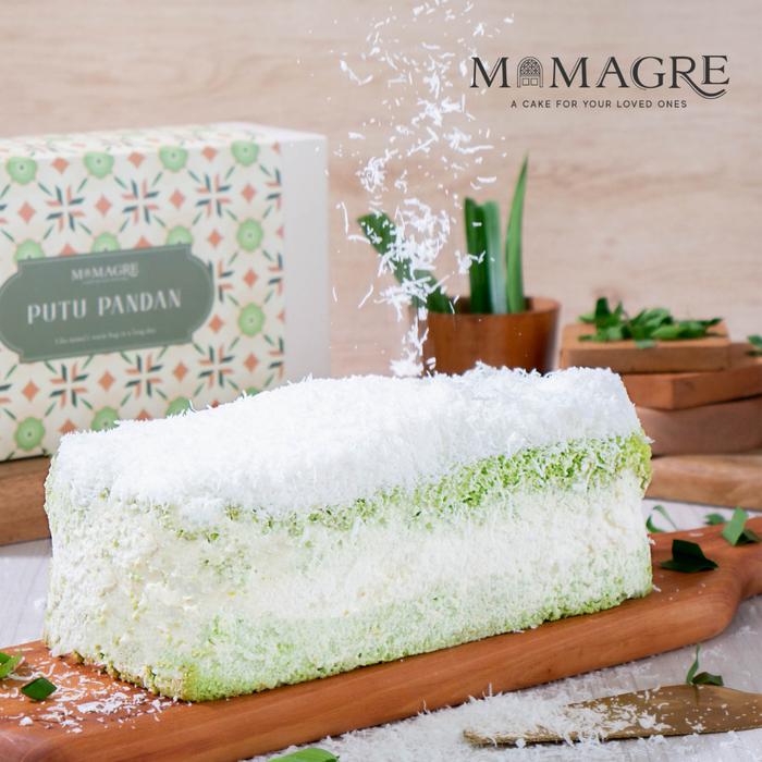Box hadiah Mamagre bermotif dengan slice cake putu pandan di sebelahnya.