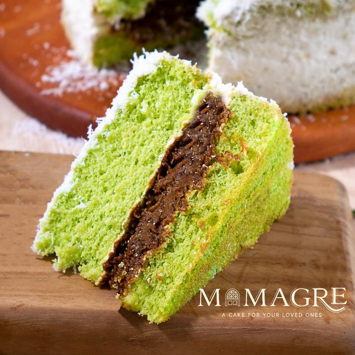 Potongan Putu Pandan Cake: bolu pandan hijau, lapisan gula aren di tengah, dibalut kelapa parut putih.